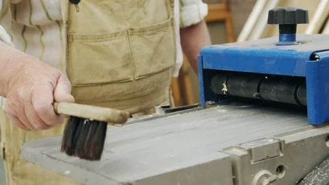Elderly man carpenter builds a small boat with his hands out of wood in a small 库存影片 89785767