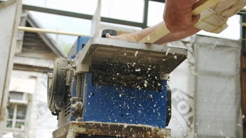 Elderly man carpenter builds a small boat with his hands out of wood in a small Stock-Footage 89786689