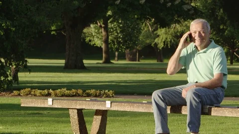 Elderly man with cellphone in the park Stock Footage 80133646