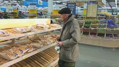 Elderly man chooses bread at Lenta supermarket Vídeo Stock 73837403