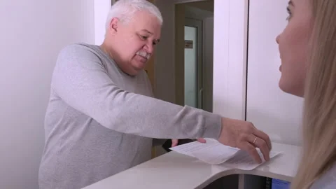 Elderly man client signing paper at reception desk In medical clinic Stock Footage 224672589