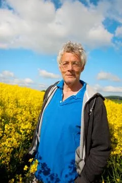 Elderly man in coleseed Stock Photos