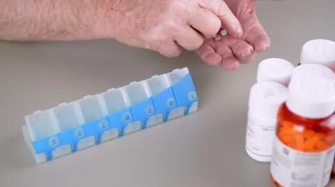 Elderly man counting and sorting pills into daily pill box. Stock Footage 58882772