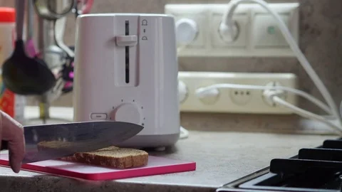 An Elderly Man Cuts The Bread And Puts It In The Toaster Stock-Footage 81568364