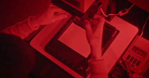 Elderly Man Developing Film in a Vintage Darkroom Under Red Safelight Vidéo 305100875