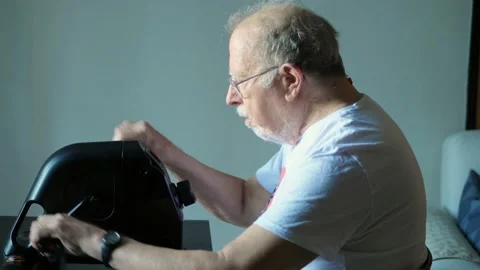 Elderly man does exercises by training his arms Stock Footage 136281254