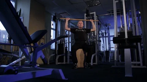 Elderly man does an isometric exercise with a stick, holding it behind the back Stock Footage 115244471