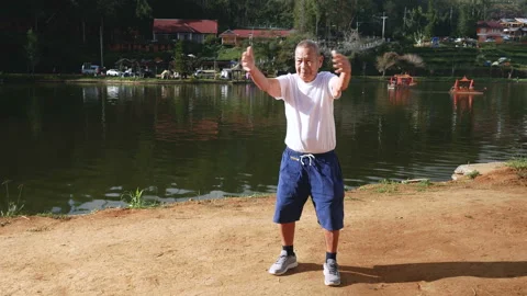 Elderly man doing exercise in park  in the morning. long shot. Stock Footage 228783112