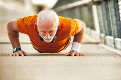 An elderly man doing push-up exercise for better quality of life Stock Photos
