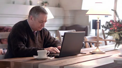 Elderly Man Drinking Coffee while Working on Laptop and Typing Smiling Stock Footage 220290922