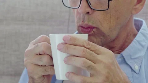 An elderly man drinks from a mug Stock Footage 169814108