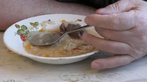 An elderly man eats soup with meat Video stock 146688492