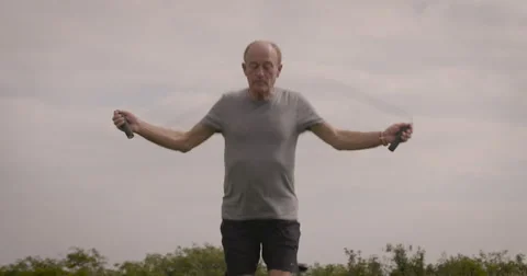 Elderly man exercising with skipping rope Stock Footage