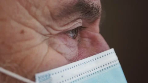 Elderly man in face mask close up. Infected man looks at the window of house. Wr Video stock 148947302