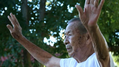Elderly man with freckled face doing exercise in park.medium shot. Stock Footage 228783138