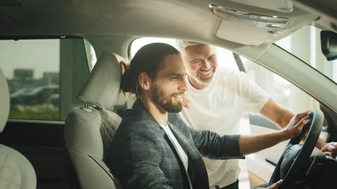 A elderly man with friendly Helpful car salesman in a car dealership are Stock Footage 240556759