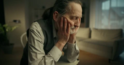 Elderly man gesturing thoughtfully in a softly lit room Stock Footage 336278051