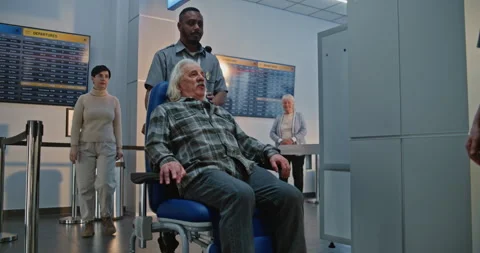 Elderly Man Getting Up from Wheelchair, Passing X-ray Metal Detector Scanner in Stock Footage 307375284