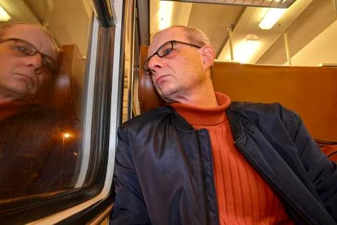 An elderly man in glasses commuting at work. Middle age man looking out of the Stock-Fotos