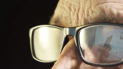 An elderly man with glasses looks at the computer screen Stock Footage 204845819