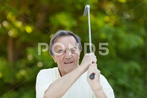 Elderly man with golf stick in action Stock Photos