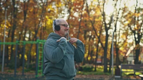 An elderly man in good spirits is exercising outside. Grandpa is having fun Stock Footage 255295209