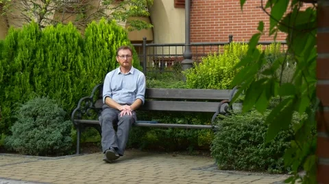 Elderly Man Has Rest on Bench in Small City Park Stock Footage 67537806