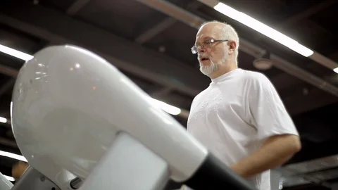 Elderly man has a treadmill Stock Footage 99790896
