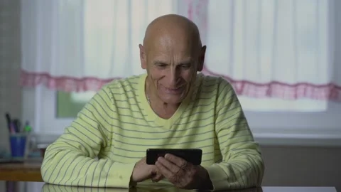 Elderly man has video call with relatives on phone at home Stock Footage 236827293