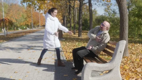 Elderly man having heart attack on park bench, passerby offers help Stock Footage 297254670