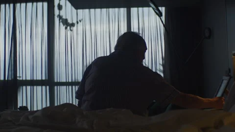 Elderly man on his bed looking at an old photo Stock Footage 264062626
