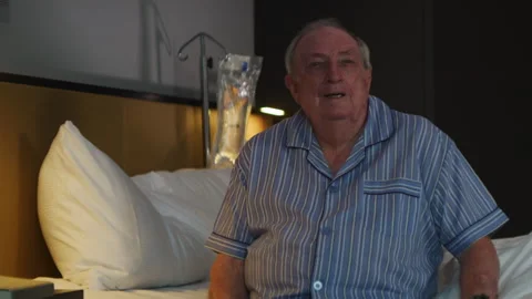 An elderly man on his bed looking at an old photo Stock Footage 264064498