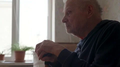 Elderly Man Holding Cane Sitting in Armchair Indoors Video stock 306084847