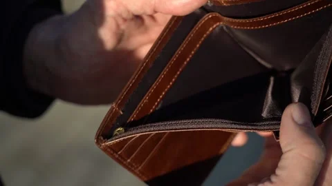 An elderly man holds an empty purse. The concept of poverty in retirement Stock Footage 152899751