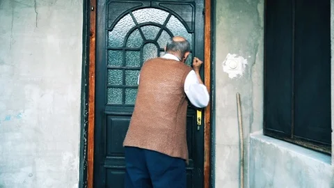 An elderly man knocks on the door of his house Vídeo Stock 97501483