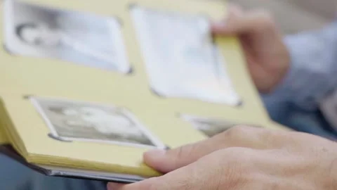 An elderly man is leafing through a photo album. 스톡 동영상 166155486