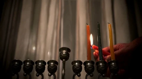 Elderly man lights candles on the third day of the Jewish holiday Hanukkah Stock Footage 86394847