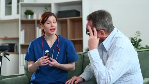 Elderly man listens as nurse explains medication dosage and instructions at.. Stock Footage 312852953