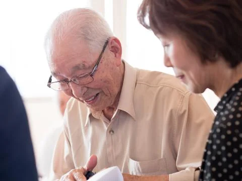 An elderly man looking at something he is receiving with great interest Stock Photos