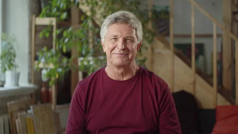 Elderly man looks at the camera and smiles a little Stock Footage 163127536