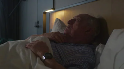 Elderly man lying in his bed and thinking about his life Stock-Footage 264061486