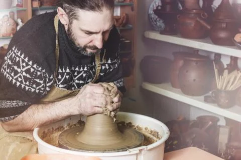 Elderly man making pot using pottery wheel in studio Stock Photos