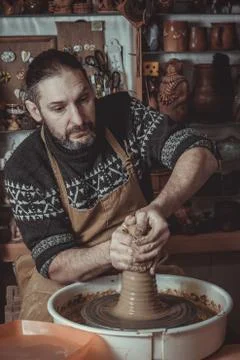 Elderly man making pot using pottery wheel in studio Stock Photos