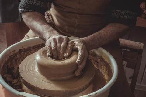 Elderly man making pot using pottery wheel in studio. Close-up. Stock Photos