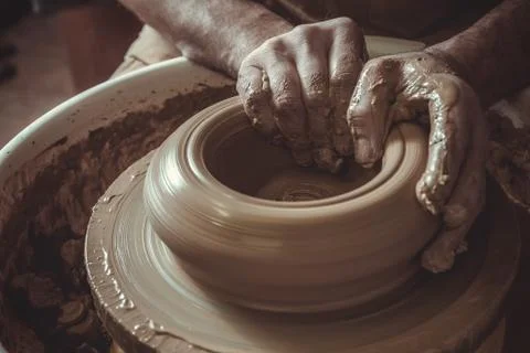 Elderly man making pot using pottery wheel in studio. Close-up. Stock Photos