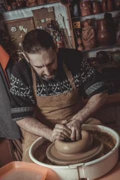 Elderly man making pot using pottery wheel in studio Stock Photos