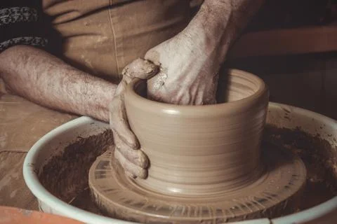 Elderly man making pot using pottery wheel in studio Stock Photos