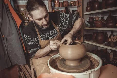 Elderly man making pot using pottery wheel in studio Stock Photos