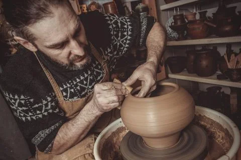 Elderly man making pot using pottery wheel in studio Stock Photos