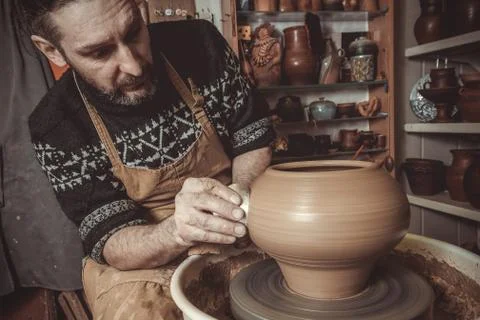 Elderly man making pot using pottery wheel in studio Stock Photos